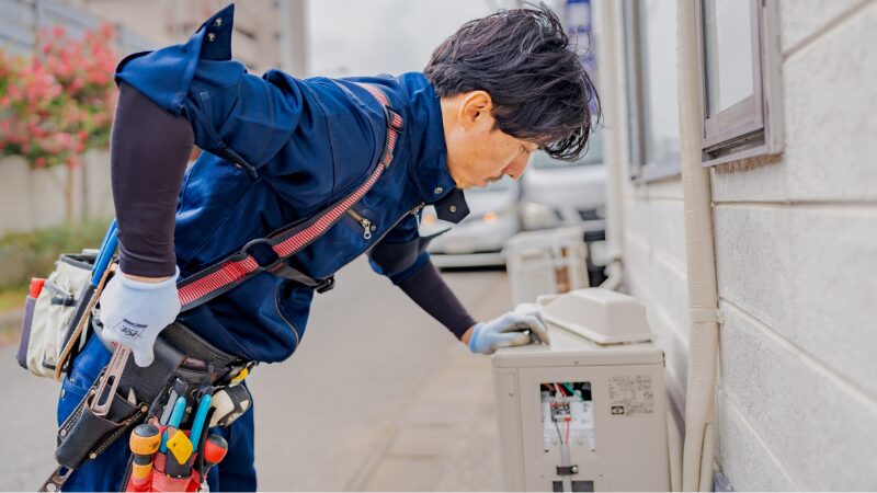 壁掛けエアコンの室内機を施工するbrightenの作業員